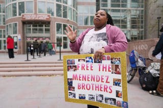 A supporter holds a sign outside of court before the Menendez brothers’ resentencing hearing Thursday
